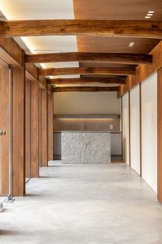 an empty room with wooden beams and white walls, in the middle of a building