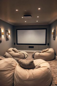 an empty room with bean bag chairs and a projector screen in the corner on the wall