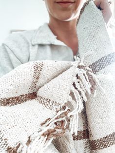 a woman is holding a white and brown blanket