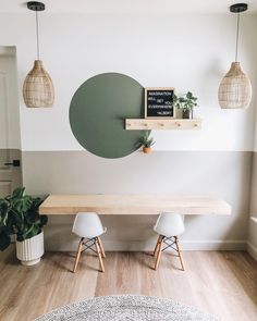 a table with two chairs and a chalkboard on the wall in front of it