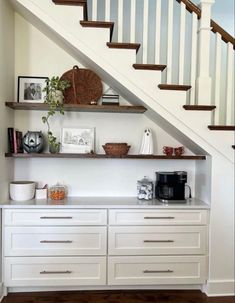 some shelves under the stairs with pictures on them