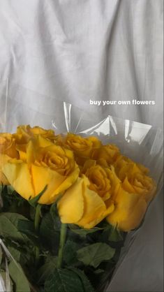 a bouquet of yellow roses wrapped in cellophane with the words buy your own flowers