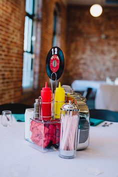 the table is set up for an event with condiments and candy bars on it