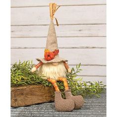 a small gnome doll sitting on top of a plant