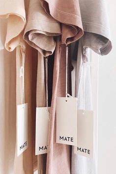 clothes hanging on a rack with tags that say mate