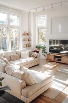 a living room filled with lots of furniture next to large windows and a flat screen tv