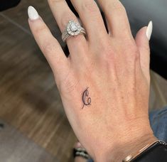 a woman's hand with a small tattoo on it