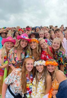 a group of young people standing next to each other in front of a large crowd