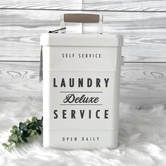 a white metal box with the words laundry deluxe service on it and a plant next to it