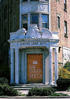 an old building with graffiti written on the front door and above it's doorway