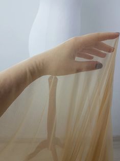 a woman's hand is shown through the sheer fabric