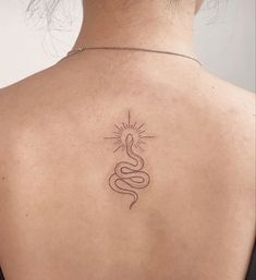 the back of a woman's shoulder with a snake tattoo on her left side