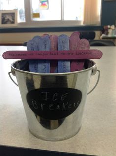 a bucket filled with pink and blue hearts sitting on top of a table