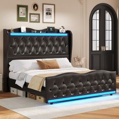 a black bed with blue lights on it's headboard and foot board in a bedroom