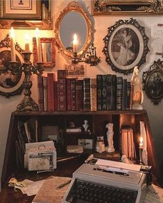 an old fashioned typewriter sitting on top of a desk next to books and candles