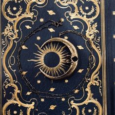 a book with a chain around it and a crescent on the cover, in gold