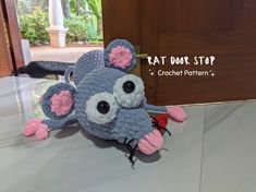 a crocheted rat is sitting on a table with the caption rat door stop