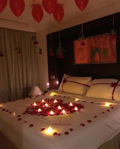 a bed that has some candles on it in the shape of heart shaped flowers and hearts