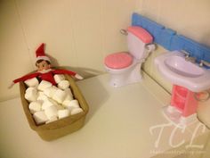 an elf is sitting in a bathtub with marshmallows on the floor