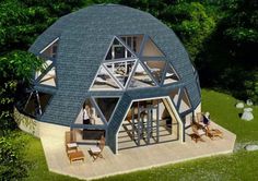 an aerial view of a round house in the middle of some trees and grass with people walking around it