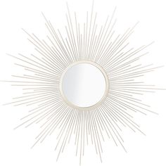 a white sunburst mirror sitting on top of a wall