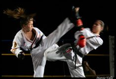 two people doing karate moves in the dark