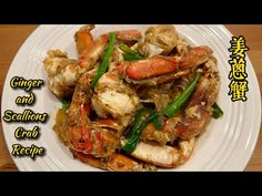 a white plate topped with cooked crabs and green beans on top of a wooden table