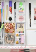 an open drawer with pens, markers, and other items in it that are on display