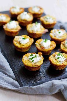 mini quiche cups with cream cheese and herbs on a slate board, ready to be eaten