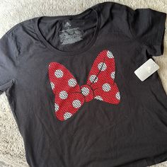 a black shirt with red and white polka dots in the shape of a bow on it