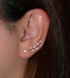 a close up of a person's ear with three piercings on it and one behind the ear