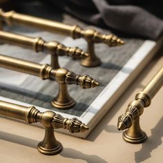 four brass candlesticks sitting on top of a table next to a mirror and cloth