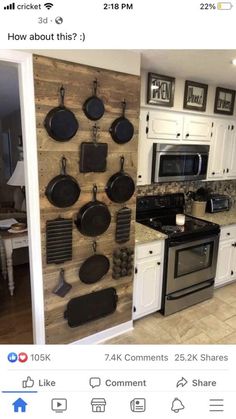 a kitchen with white cabinets and black pans hanging on the wall next to an oven