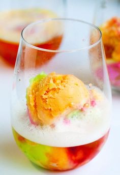 an ice cream sundae in a wine glass on a table with other desserts