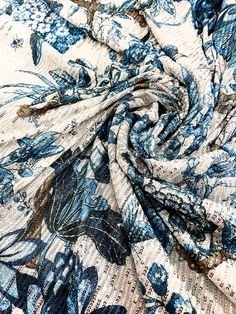 a blue and white floral print fabric with large flowers on the bottom half of it