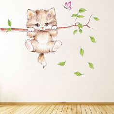 a cat sitting on a branch with leaves and flowers painted on the wall behind it