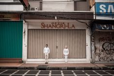 two people standing in front of a building