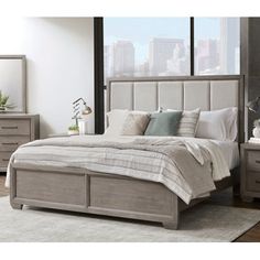 a bedroom with a bed, dressers and mirror in it's center area