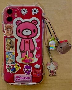 a cell phone case with stickers on it and a keychain attached to the back