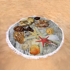 a round beach towel with seashells and starfish on it