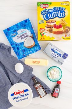 ingredients to make an ice cream dessert laid out on a white counter top, including yogurt, butter, sugar, and other items