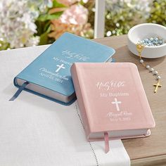 two pink and blue personalized bibles on a table