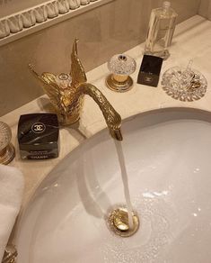 a bathroom sink with gold faucet and soap dispenser