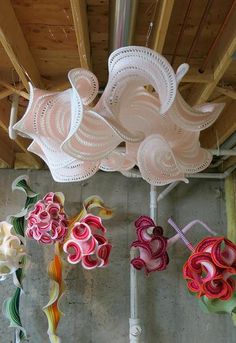 colorful paper flowers are hanging from the ceiling