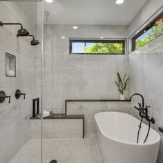 a white bath tub sitting next to a walk in shower