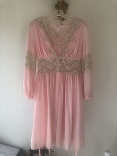 This beautiful vintage pink nightgown and robe is a unique and rare find. This set does have various stains throughout, but if treated with further care it can be a wonderful addition to your vintage collection.  Robe Bust Measurement: 30"  Robe Waist Measurement: 26"  Robe Length: 35"  Nightgown Bust Measurement: 33" Nightgown Waist Measurement: 27" Nightgown Length: 35" Pink Long Sleeve Nightgown For Wedding Night, Pink Dress With Lace Trim For Wedding Night, Pink Feminine Nightgown For Wedding Night, Vintage Pink Sleepwear, Vintage V-neck Sleep Dress, Pink Feminine Nightgown, Feminine Pink Nightgown, Vintage Wedding Sleepwear With Lace Trim, Vintage V-neck Wedding Sleepwear