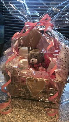 a teddy bear sitting in a basket filled with gifts