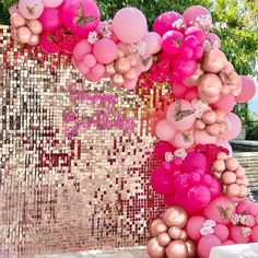 pink and gold balloons are hanging from the side of a wall with sequins