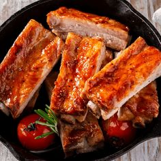 two pieces of meat sitting on top of a pan covered in ketchup and sauce