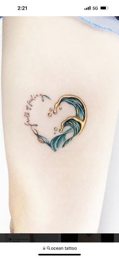 a small tattoo on the side of a woman's lower thigh with waves coming out of it